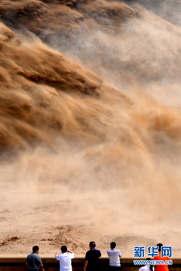 Tourists watch water gushing out from the Xiaolangdi Reservoir on the Yellow River during a sand-washing operation in Luoyang, central China's Henan Province, July 5, 2013. The on-going operation, conducted on Friday, works by discharging water at a volume of 2,600 cubic meters per second from the reservoir to clear up the sediment in the Yellow River , the country's second-longest waterway. Speeding currents would carry tons of sand into the sea. The Yellow River has been plagued by an increasing amount of mud and sand. Each year, the river bed rises as silt deposits build up, slowing the water flow in the lower reaches. (Xinhua/Miao Qiu Nao)