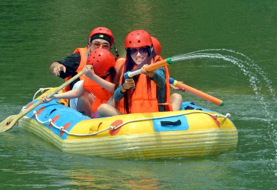 Tourists navigate a river during a river rafting festival at Jincun Township in Ruyang County, central China's Henan Province, July 6, 2013. (Xinhua/Wang Song)