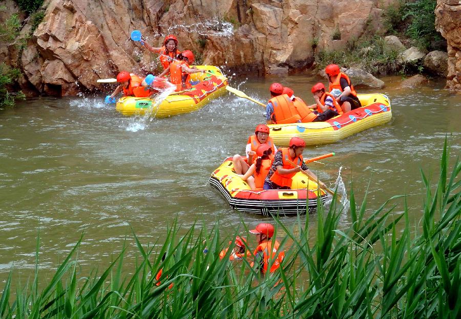 Tourists navigate a river during a river rafting festival at Jincun Township in Ruyang County, central China's Henan Province, July 6, 2013. (Xinhua/Wang Song)