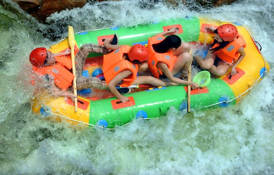 Tourists navigate a river during a river rafting festival at Jincun Township in Ruyang County, central China's Henan Province, July 6, 2013. (Xinhua/Wang Song)