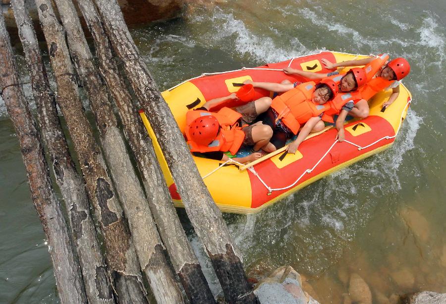 Tourists navigate a river during a river rafting festival at Jincun Township in Ruyang County, central China's Henan Province, July 6, 2013. (Xinhua/Wang Song)