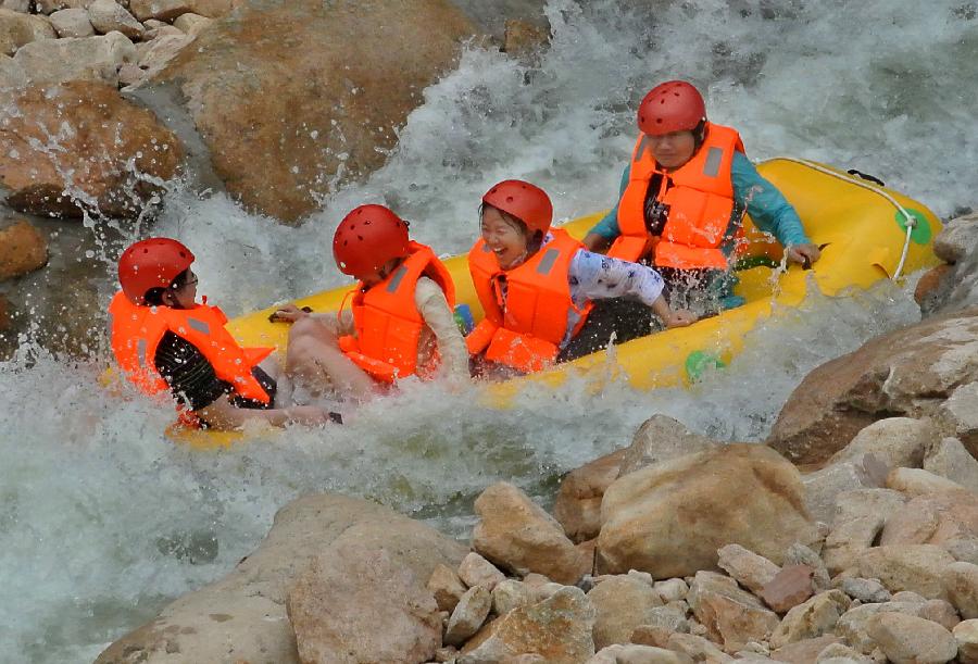 Tourists navigate a river during a river rafting festival at Jincun Township in Ruyang County, central China's Henan Province, July 6, 2013. (Xinhua/Wang Song)