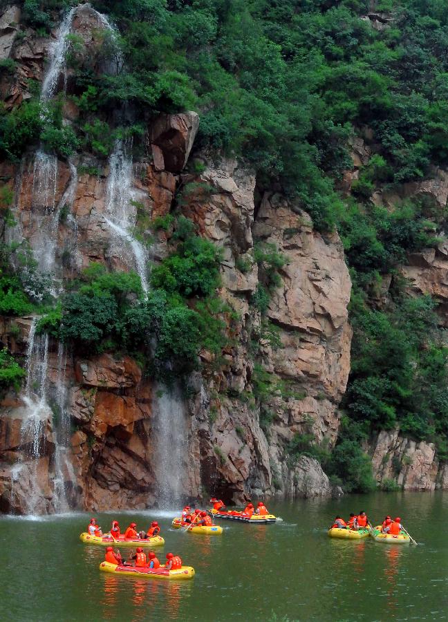 Tourists navigate a river during a river rafting festival at Jincun Township in Ruyang County, central China's Henan Province, July 6, 2013. (Xinhua/Wang Song)