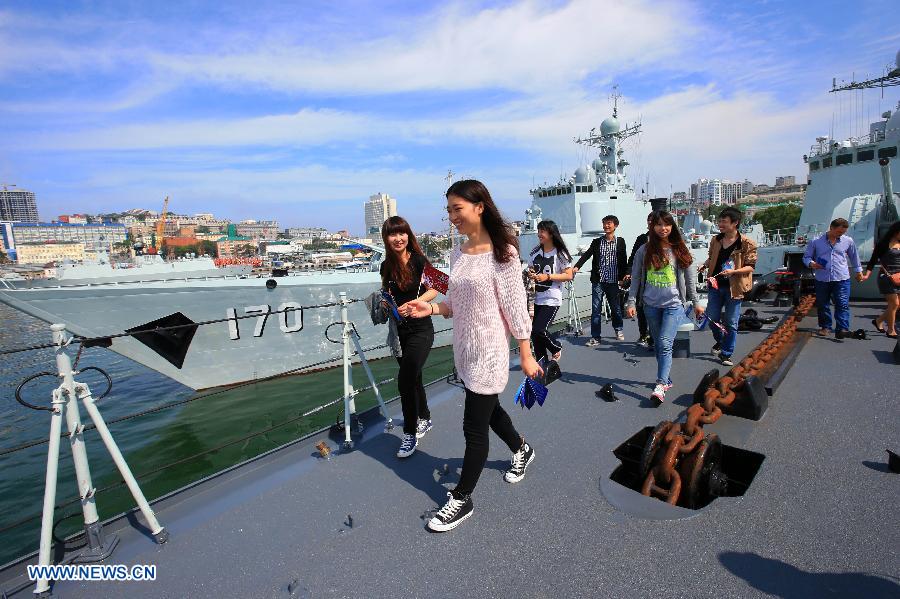 Chinese overseas students in Russia visit the Chinese Navy Shijiazhuang guided-missile destroyer at the port in Vladivostok, Russia, July 6, 2013. The Chinese Navy Shijiazhuang guided-missile destroyer, which is participating in the "Joint Sea-2013" joint naval drills of China and Russia, opened to the public and Russian navy soldiers on Saturday. (Xinhua/Zha Chunming)