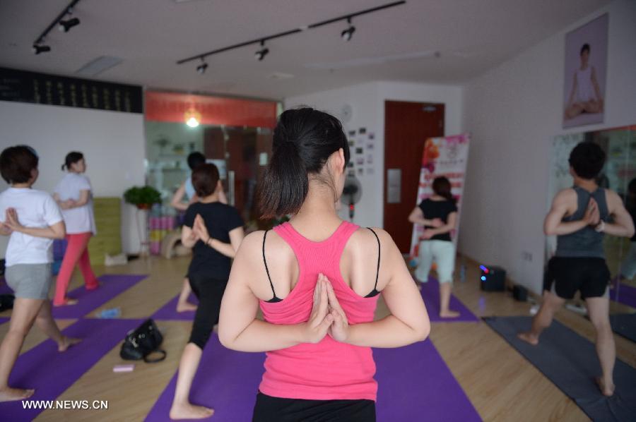 Participants practice hot yoga at a studio maintained at about 42 degrees Celsius in Nanchang, capital of east China's Jiangxi Province, July 5, 2013. (Xinhua/Zhou Mi) 