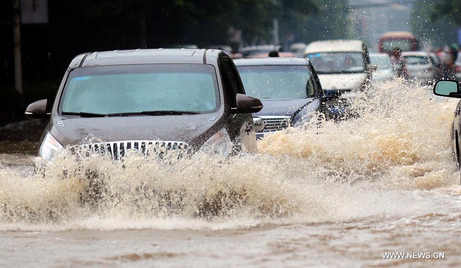 Cars drive on the flooded road in Wuhan, capital of central China's Hubei Province, July 7, 2013. Wuhan was hit by the heaviest rainstorm in five years from Saturday to Sunday. The local meteorologic center has issued red alert for rainstorm for many times in sequence. (Xinhua/Cheng Min) 