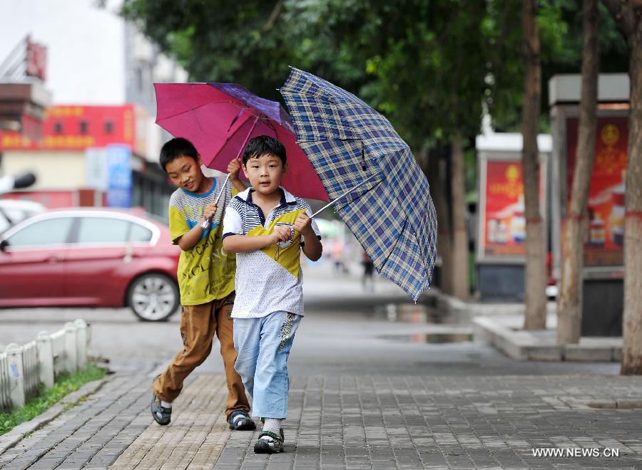 Two boys walk under umbrellas in Yinchuan, capital of northwest China's Ningxia Hui Autonomous Region, July 7, 2013. Xiaoshu (Lesser Heat), the 11th of the 24 solar terms in the Chinese Lunar Calendar which means the beginning of hot summer, fell on Saturday. Rainfall brought cool to Yinchuan on Xiaoshu. (Xinhua/Peng Zhaozhi)