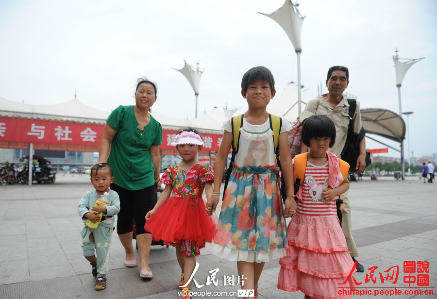 Several children accompanied by adults take the train to spend holidays with their parents working in cities at Fuyang Railway Station, east China's Anhui province, July 1, 2013. (photo/vip.people.com.cn)