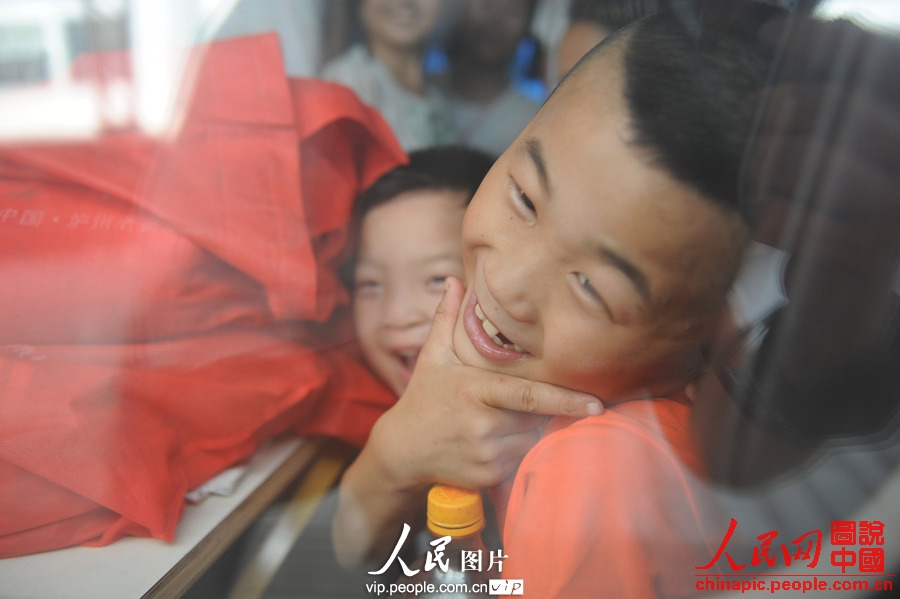 Several children accompanied by adults take the train to spend holidays with their parents working in cities at Fuyang Railway Station, east China's Anhui province, July 2, 2013. (photo/vip.people.com.cn)