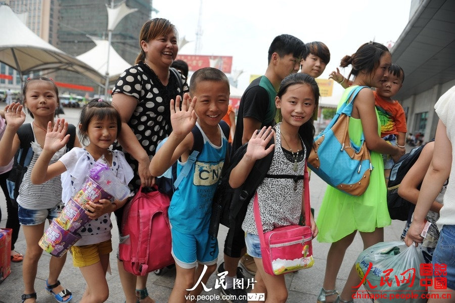 Several children accompanied by adults take the train to spend holidays with their parents working in cities at Fuyang Railway Station, east China's Anhui province, July 1, 2013. (photo/vip.people.com.cn)