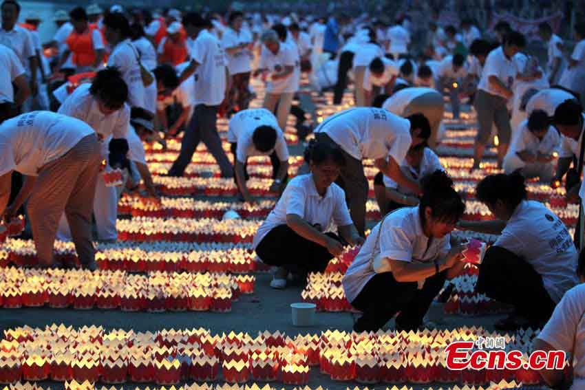 People prepare river lanterns in Northeast China's Jilin Province, July 7, 2013. Altogether 14,630 lanterns were released in the Songhua River, setting a new Guinness World Record.  (CNS/Cang Yan)