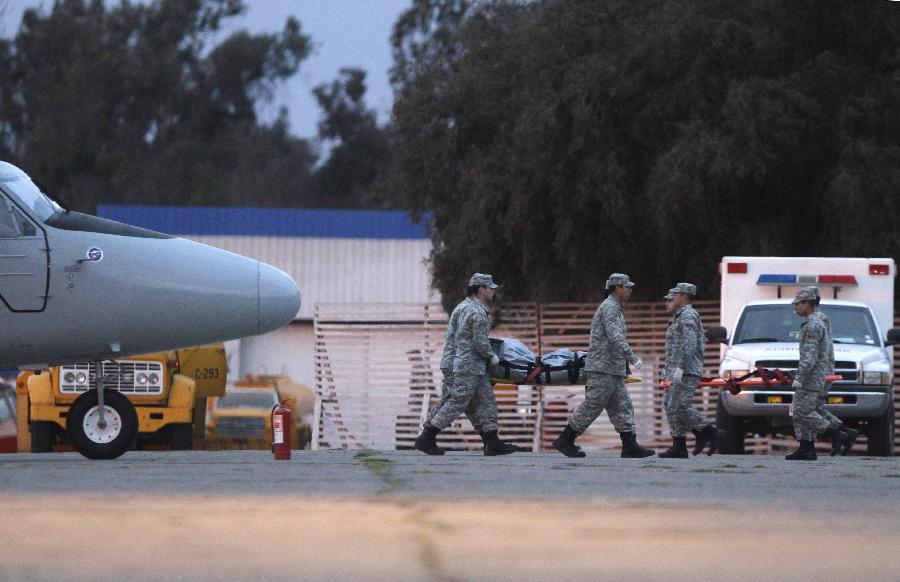 Military personnel move the body of the four victims in an air accident near Juan Hernandez Islands in Santiago, capital of Chile, Sept. 3, 2011. An aircraft with 21 passengers onboard including a television team crashed near the Juan Hernandez islands, about 700 kilometers off the continent. (Xinhua/Victor Rojas)