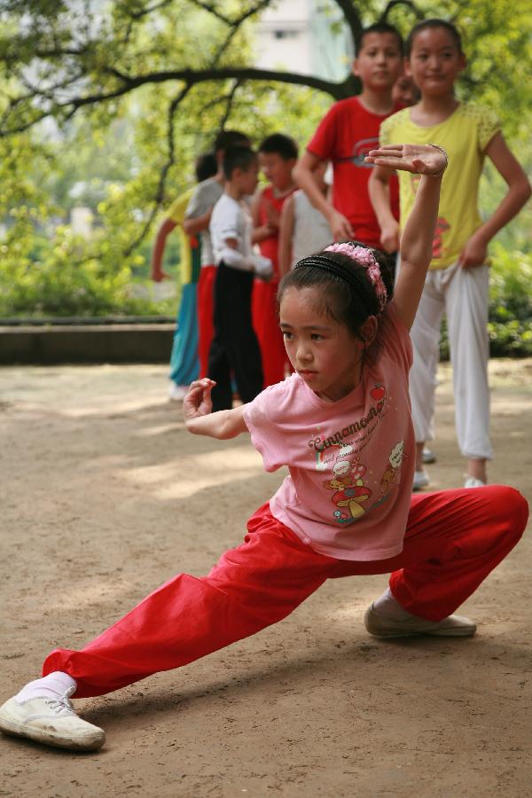 A young girl practises martial arts during her summer vacation in Nantong City, east China's Jiangsu Province, July 7, 2013. (Xinhua/Cui Genyuan)