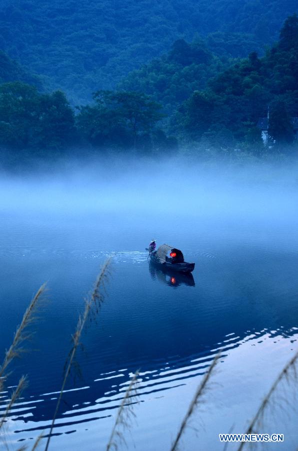 A fisherman fishes on the Xiaodongjiang River in Zixing City, central China's Hunan Province, July 7, 2013. (Xinhua/He Maofeng)