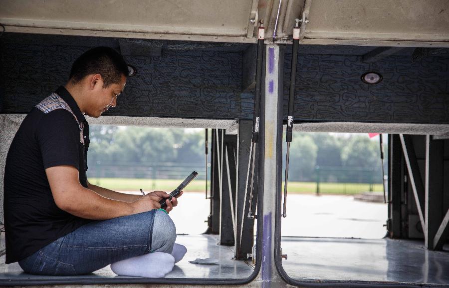 A bus driver escapes himself from scorching weather in a bus in Nantong City, east China's Jiangsu Province, July 8, 2013. The rainy season ends on Monday July 8 and high temperature may hit 36 degrees Celsius in a few days in the southern Huaihe River region in east China's Jiangsu Province, according to the local meteorological observatory. (Xinhua/Huangzhe)