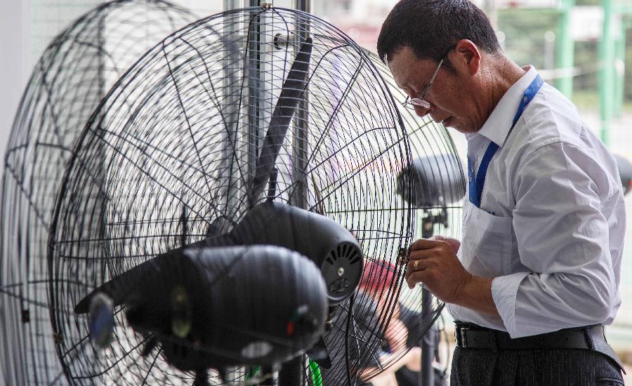 A staff worker fixes an electric fan in Nantong City, east China's Jiangsu Province, July 8, 2013. The rainy season ends on Monday July 8 and high temperature may hit 36 degrees Celsius in a few days in the southern Huaihe River region in east China's Jiangsu Province, according to the local meteorological observatory. (Xinhua/Huangzhe) 