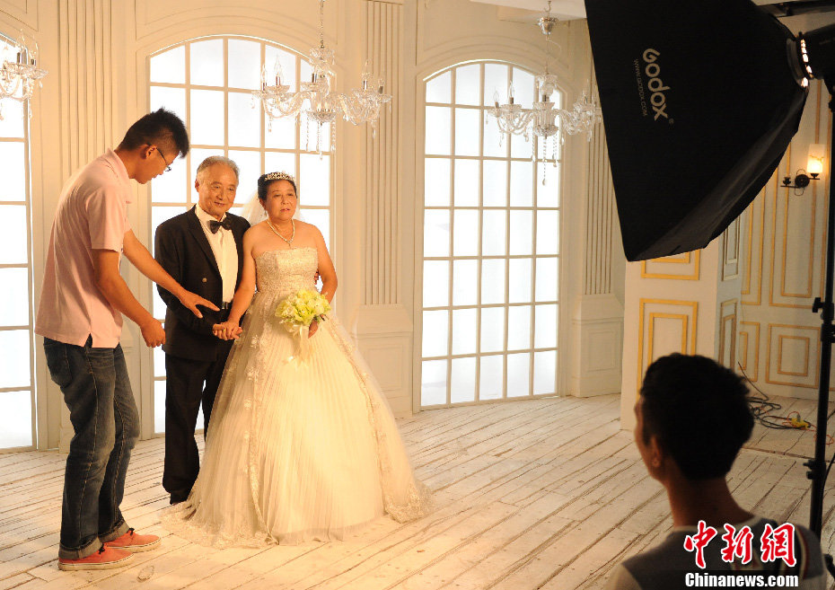 11 pairs of old couples who are more than 80 years old pose for wedding photos to express the love to each other on July 6, 2013. The students of Hefei Industrial University used the prize money they won in a contest to support the photo shooting. (Photo/chinanews.com)