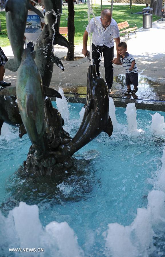 A boy watches a fountain in the Gezi park in Istanbul on July 8, 2013. Turkey's Gezi Park was opened to the public Monday after a week-long closure, Istanbul Governor Huseyin Avni Mutlu announced. (Xinhua/Lu Zhe)