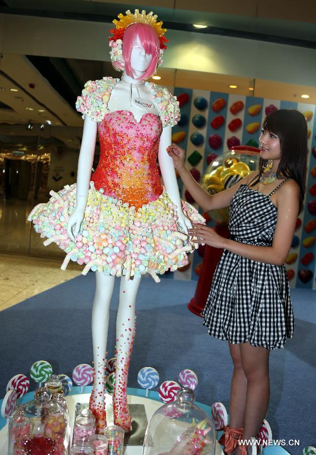 Lilian Kan (R), a Hong Kong designer, presents her candy dress at Citygate Outlets in south China's Hong Kong, July 8, 2013. Kan showed her self-designed shoes and apparels made of candies here on Monday. (Xinhua/Li Peng)