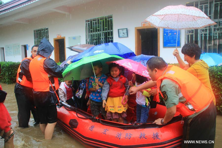 Officers transfer children with a kayak at a kindergarten in Yingjiang County, southwest China's Yunnan Province, July 8, 2013. Rainstorm-triggered floods have affected about 4,882 people in the county, causing damages to local agriculture and houses. The rescue operation is under way. (Xinhua)