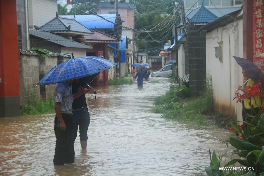 Local residents walk in the flooded street in Pingyuan Town of Yingjiang County, southwest China's Yunnan Province, July 8, 2013. Rainstorm-triggered floods have affected about 4,882 people in the county, causing damages to local agriculture and houses. The rescue operation is under way. (Xinhua)