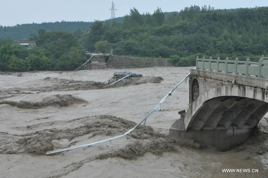 Photo taken on July 9, 2013 shows the collapsed old Qinglian Bridge across the Tongkou River in Jiangyou City, southwest China's Sichuan Province. An unknown number of vehicles and pedestrians fell into the river after the bridge collapsed on the morning of July 9. The water level of the river rose significantly over the past two days due to continuous rainfalls in the region. (Xinhua) 