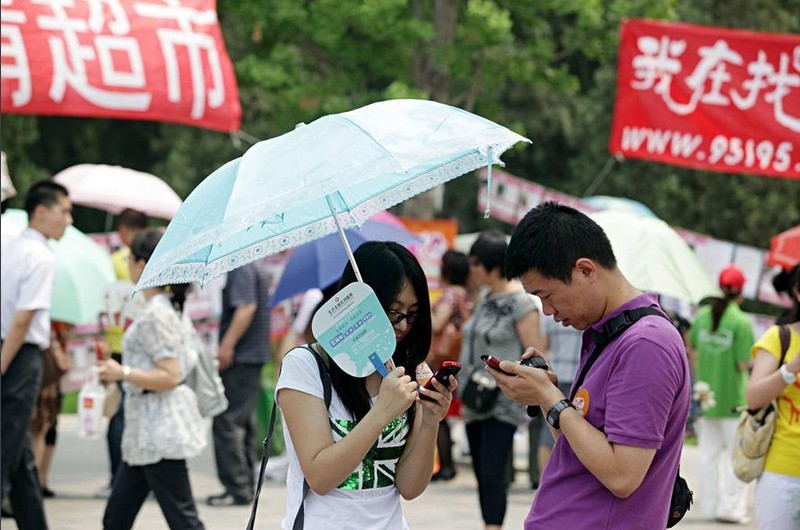 A woman and a man exchange their phone numbers during the blind date event in park.