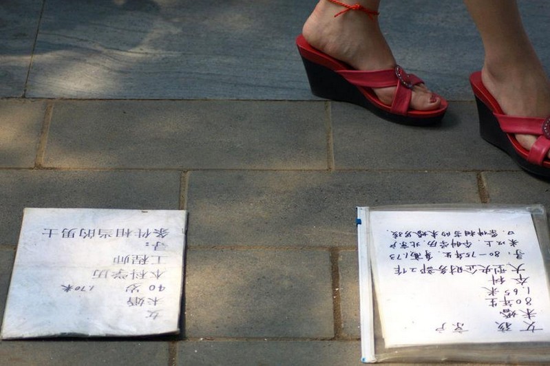 A woman passes by cards of information of unmarried youngsters