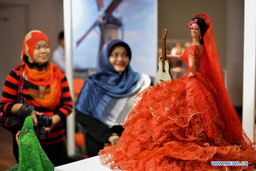 Visitors watch dolls dressed in Spanish traditional costume during the World Costumes Dolls Exhibition in Kuala Lumpur, in Malaysia, on July 9, 2013. (Xinhua/Chong Voon Chung)