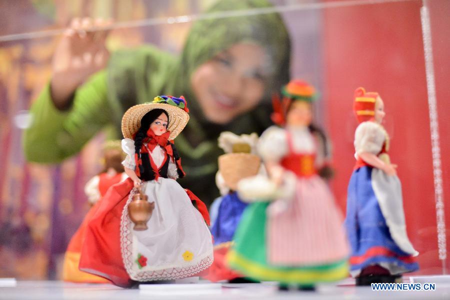 A visitor watches dolls dressed in Italian traditional costume during the World Costumes Dolls Exhibition in Kuala Lumpur, in Malaysia, on July 9, 2013. (Xinhua/Chong Voon Chung) 