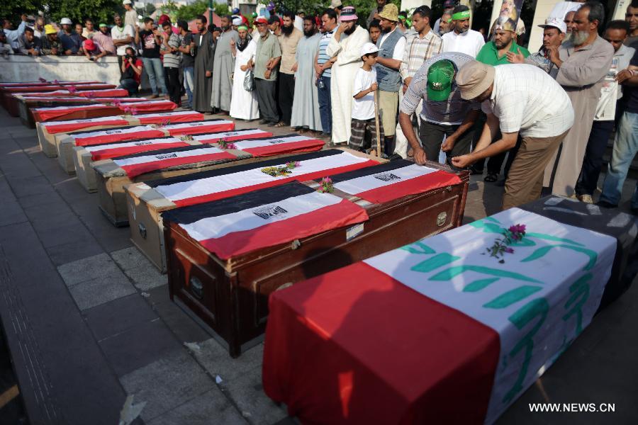 Supporters of ousted president Mohamed Morsi gather around coffins, one day after fellow protesters were killed in clashes, inside Rabaa al-Adawiya mosque in Cairo, July 9, 2013. Clashes between Islamist protesters and the army in Cairo on July 9 killed at least 51 and injured 435 others. (Xinhua/Wissam Nassar) 