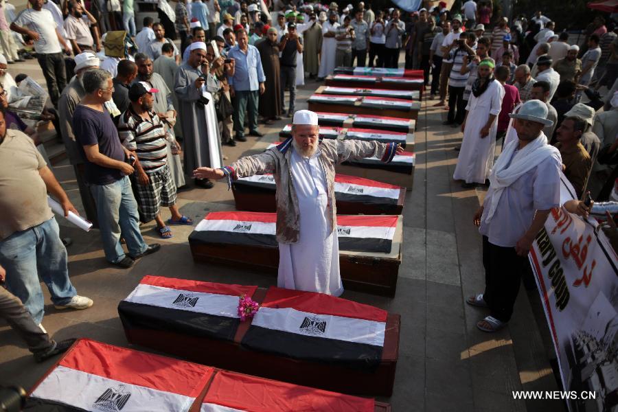 Supporters of ousted president Mohamed Morsi gather around coffins, one day after fellow protesters were killed in clashes, inside Rabaa al-Adawiya mosque in Cairo, July 9, 2013. Clashes between Islamist protesters and the army in Cairo on July 9 killed at least 51 and injured 435 others. (Xinhua/Wissam Nassar) 