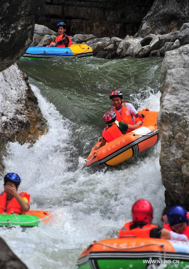 Tourists raft on the water at the Chaotianhou scenery spot in Xingshan County, central China's Hubei Province, July 9, 2013. Large number of tourists headed for Chaotianhou to raft due to the lingering heat wave recently in the province. (Xinhua/Du Huaju)