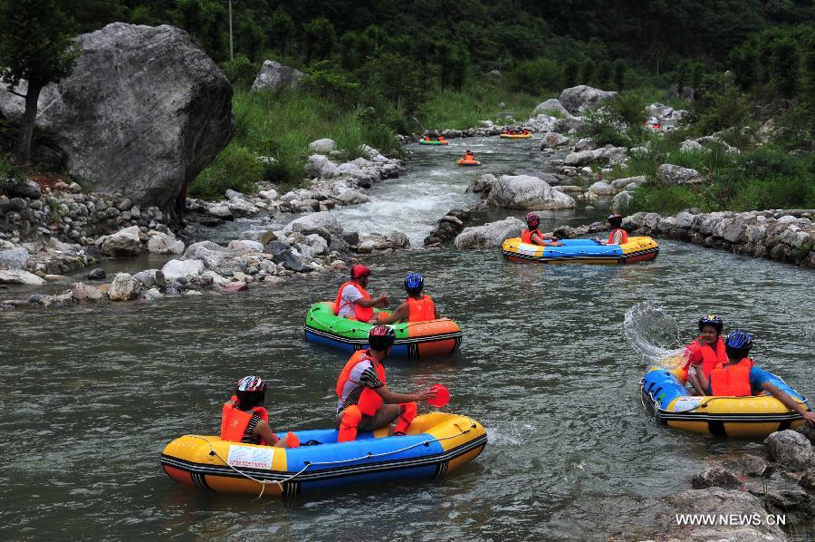 Tourists raft on the water at the Chaotianhou scenery spot in Xingshan County, central China's Hubei Province, July 9, 2013. Large number of tourists headed for Chaotianhou to raft due to the lingering heat wave recently in the province. (Xinhua/Du Huaju)