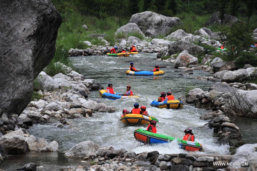 Tourists raft on the water at the Chaotianhou scenery spot in Xingshan County, central China's Hubei Province, July 9, 2013. Large number of tourists headed for Chaotianhou to raft due to the lingering heat wave recently in the province. (Xinhua/Du Huaju)