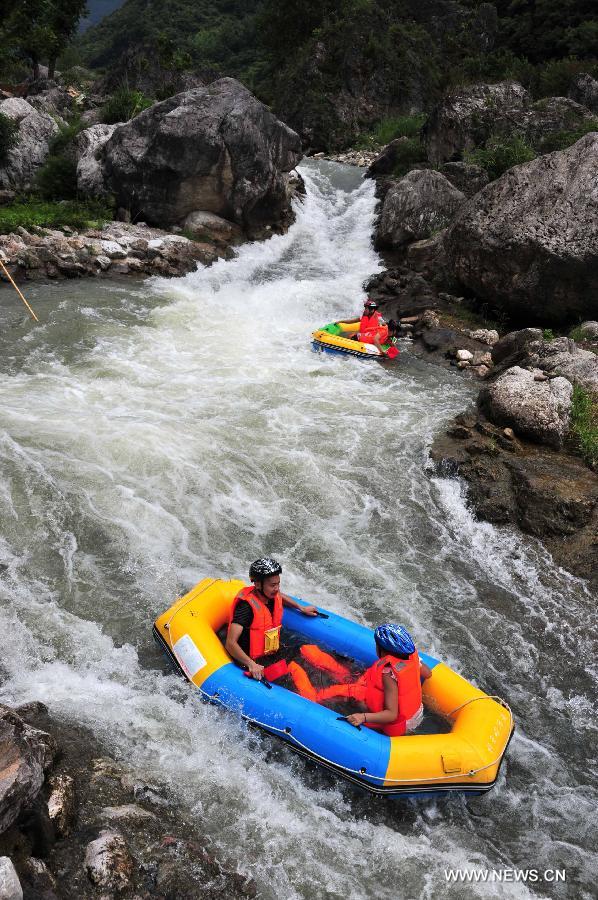 Tourists raft on the water at the Chaotianhou scenery spot in Xingshan County, central China's Hubei Province, July 9, 2013. Large number of tourists headed for Chaotianhou to raft due to the lingering heat wave recently in the province. (Xinhua/Du Huaju)