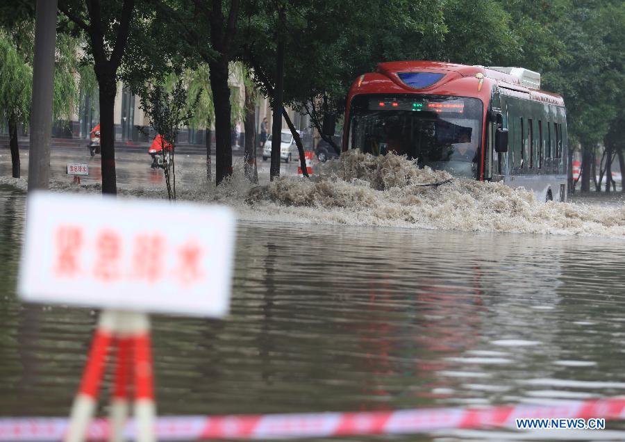 A bus runs on the flooded Nanneihuan Street in Taiyuan City, capital of north China's Shanxi Province, July 9, 2013. A heavy rainfall hit many regions of Shanxi Province on Tuesday. Parts of Taiyuan City was seriously flooded and the traffic was disrupted. (Xinhua/Shi Xiaobo)