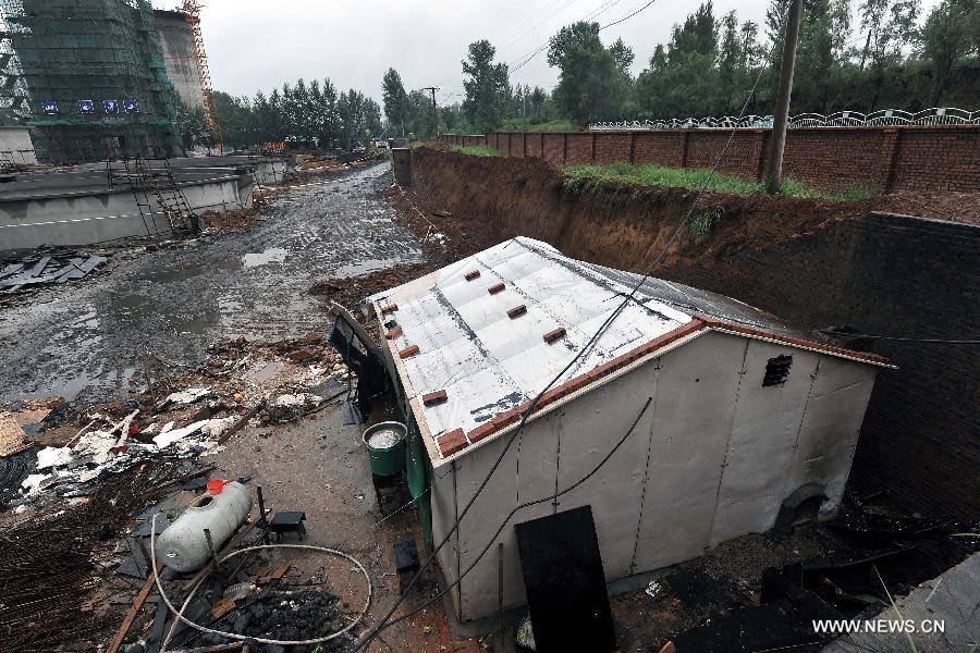 Photo taken on July 10, 2013 shows the collapsed wall and make-shift houses at a construction site of a coal cleaning plant of Dacheng Liyuan Coalification Co., Ltd at Pingshu Village of Pingshu Township in Shouyang County, north China's Shanxi Province, July 10, 2013. Twelve construction workers were killed and seven others injured after their make-shift house was buried by a collapsed wall on Tuesday evening. Rescue work has ended by Wednesday morning. (Xinhua/Zhan Yan)