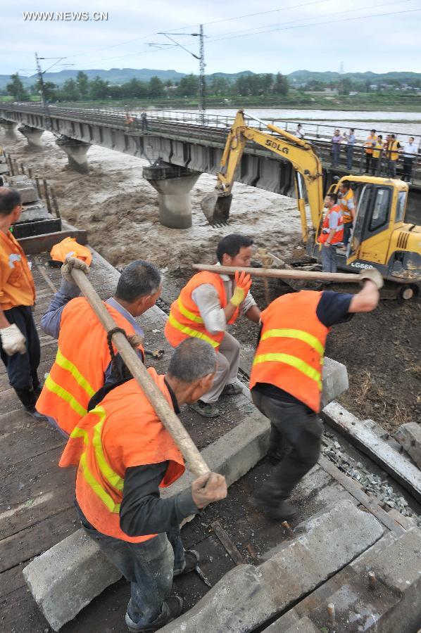 Workers repair the parapet wall, which was destroyed by rainstorm-triggered flood, of the upline of the Mianyuan River Bridge of the Baoji-Chengdu Railway in southwest China's Sichuan Province, July 10, 2013. The upline of the bridge has been closed while the downlink remained open for railway traffic. (Xinhua/Wang Zhengwei) 