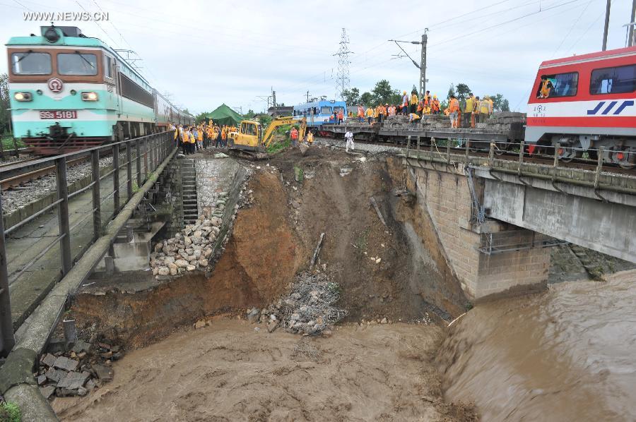 Workers repair the parapet wall, which was destroyed by rainstorm-triggered flood, of the upline of the Mianyuan River Bridge of the Baoji-Chengdu Railway in southwest China's Sichuan Province, July 10, 2013. The upline of the bridge has been closed while the downlink remained open for railway traffic. (Xinhua/Wang Zhengwei)