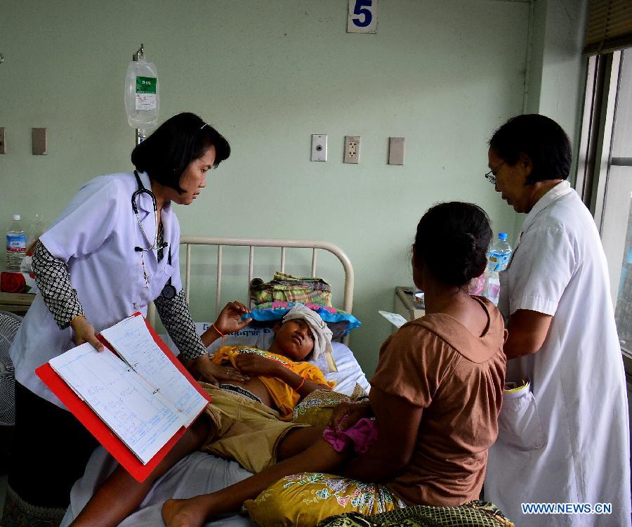 A doctor diagnoses a patient suffering from dengue fever at a hospital in Vientiane, Laos, July 10, 2013. The Lao government announced on Monday the release of 2 billion kip (about 250,000 U.S.dollars) to combat the spread of dengue fever in the country, local media reported. Director General of the Communicable Disease Control Department of the Lao Ministry of Health Dr. Bounlay Phommasack said that in the first six months of this year 20,367 infections, with 64 deaths, were reported.(Xinhua/Allen Liu)