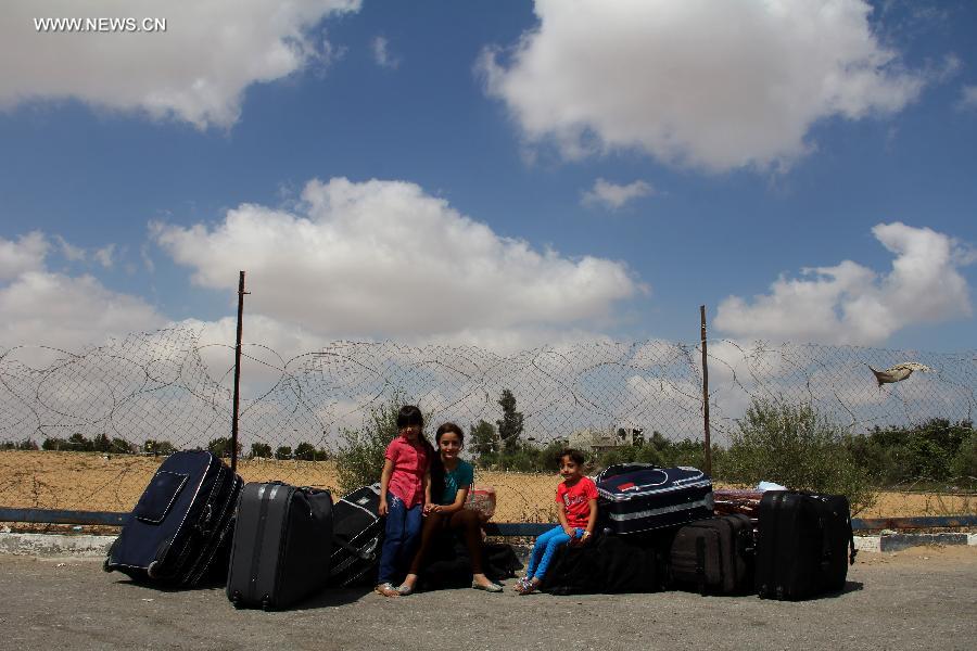 Palestinian passengers wait outside the departure lounge at Rafah crossing point with Egypt in the southern Gaza Strip on July 10, 2013. Egypt reopened the main crossing point of the Gaza Strip temporarily after six days of consecutive closure. Ghazi Hamad, Hamas's deputy foreign minister, said the crossing would remain open for a few hours on Wednesday so Palestinians could return and so foreigners, patients due to receive medical treatment in Cairo and Palestinians with residency permits in third countries could leave the Gaza Strip. (Xinhua/Khaled Omar)