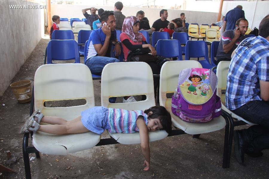 Palestinian passengers wait outside the departure lounge at Rafah crossing point with Egypt in the southern Gaza Strip on July 10, 2013. Egypt reopened the main crossing point of the Gaza Strip temporarily after six days of consecutive closure. Ghazi Hamad, Hamas's deputy foreign minister, said the crossing would remain open for a few hours on Wednesday so Palestinians could return and so foreigners, patients due to receive medical treatment in Cairo and Palestinians with residency permits in third countries could leave the Gaza Strip. (Xinhua/Khaled Omar)