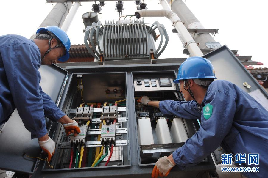 Maintenance workers of the power company of Shenzhou examine all the powered devices to ensure high reliability under heavy power load on July 3, 2013 in Shenzhou , north China's Hebei province. (Photo/Xinhua)