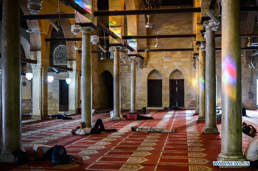 Egyptian Muslims sleep waiting for the time to break their fast at Al-Azhar Mosque on the first day of the holy month of Ramadan in Cairo, Egypt, July 10, 2013. (Xinhua/Qin Haishi) 