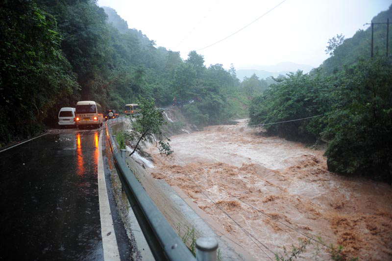 A rain-triggered landslide crushes roads in Zhongxing county, southwest China's Sichuan province on July 10, 2013. Rain-triggered mountain torrents and landslides buried 11 households, leaving two people dead and 21 missing. As of 9:45 p.m., 352 people stranded have been relocated to safe areas. (Xinhua/Liu Jie) 