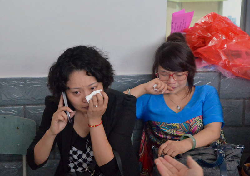 Two women wait for news in a temporary settlement in flood-hit Zhongxin county, southwest China's Sichuan province, July 10, 2013. Rain-triggered mountain torrents and landslides buried 11 households, leaving two people dead and 21 missing. As of 9:45 p.m., 352 people stranded have been relocated to safe areas. (Xinhua/Liu Jie)