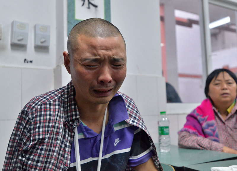 A man cries in a temporary settlement site in flood-hit Zhongxin county , Dujiangyan, southwest China's Sichuan province, July 10, 2013. Rain-triggered mountain torrents and landslides buried 11 households, leaving two people dead and 21 missing. As of 9:45 p.m., 352 people stranded have been relocated to safe areas. (Xinhua/Liu Jie) 