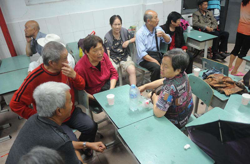 Relocated people rest at a school served as a settlement site in Zhongxing town, Dujiangyan, southwest China's Sichuan province on July 10, 2013. Rain-triggered mountain torrents and landslides buried 11 households, leaving two people dead and 21 missing. As of 9:45 p.m., 352 people stranded have been relocated to safe areas. (Xinhua/ Xue Yubin)