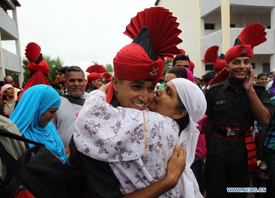 Mother of a recruit of Indian army hugs her son after a passing out parade at an army base on the outskirts of Srinagar, the summer capital of Indian-controlled Kashmir, July 10, 2013. The 494 recruits from Indian-controlled Kashmir were formally inducted into the Indian army's Jammu Kashmir Light Infantry (JAKLI) regiment after rigorous training. (Xinhua/Javed Dar)